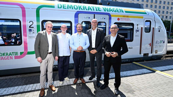 Mehrere Personen vor dem "Demokratie Wagen".