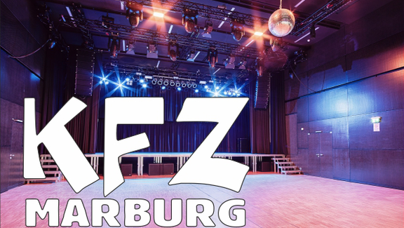 purple illuminated stage, on it the writing "KFZ Marburg".