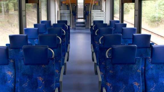 Inside of a train wagon with empty blue seats