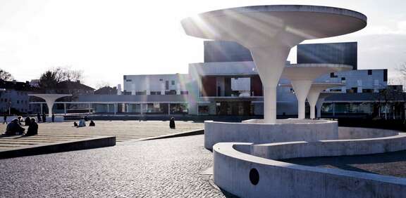 Blick auf das Staatstheater Darmstadt, asphaltierter Platz mit futuristischer weißer Architektur