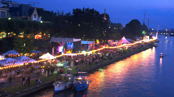 Abendliches Mainufer mit Festzelten und Besuchern