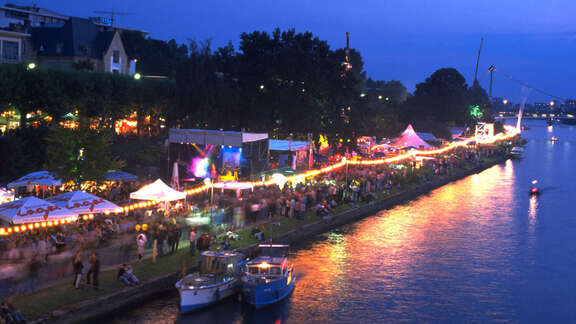 Abendliches Mainufer mit Festzelten und Besuchern
