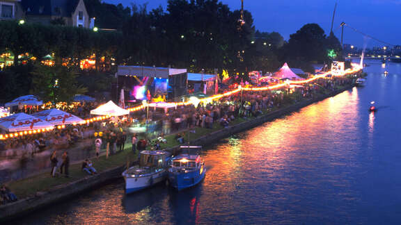 Abendliches Mainufer mit Festzelten und Besuchern