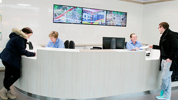 A service desk with two employees and two clients at each end