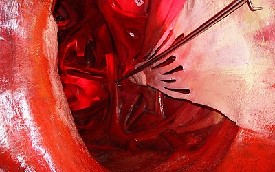 Vergrößerte Ansicht: Roter, dem Herzen nachempfundener Tunneldurchgang mit Haltestange