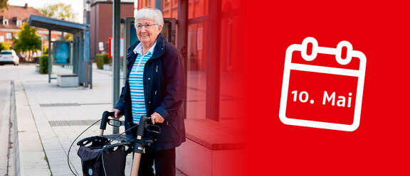 Ältere Frau mit weißem Haar steht mit einem Rollator an einer Bushaltestelle und lächelt. Rechts im Bild ist ein roter Hintergrund mit einem Kalendersymbol und dem Datum "10. Mai".