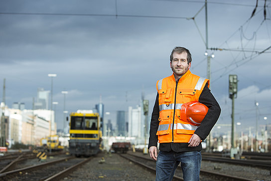 Arbeiter vor Skyline Arbeiter im Vordergrund, dahinter ein Bauzug und die Frankfurter Skyline