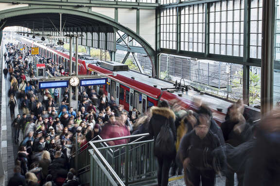 Viele Menschen kommen aus einer S-Bahn und überfüllen den Bahnsteig sowie die Bahnsteigtreppe.