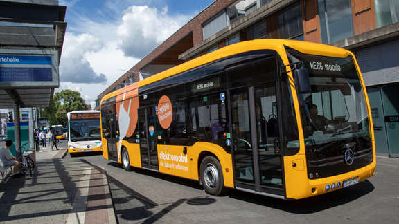 Vergrößerte Ansicht: Gelber Elektrobus an einer Haltestelle