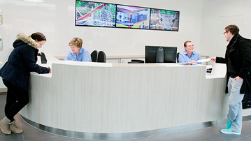 A service desk with two employees and two clients at each end