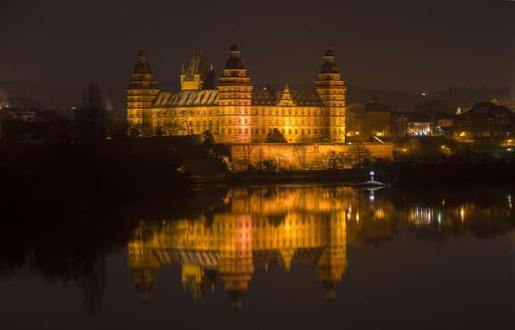 Schloss Johannisburg illuminiert bei Nacht.