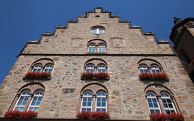 Vergrößerte Ansicht: Nahaufnahme: großes Steinhaus mit Blumen vor den Fenstern