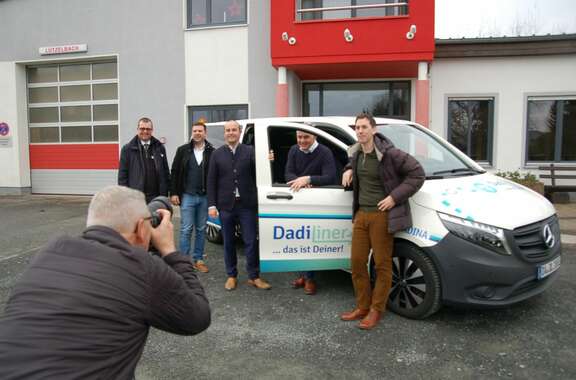 DadiLiner als fester Bestandteil - Modautal Fünf Männer stehen an einem weißen Auto mit der Aufschrift: DadiLiner. Im Vordergrund macht ein Mann ein Foto davon.
