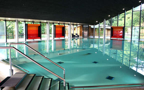 Vergrößerte Ansicht: Schwimmbecken in hellem Raum mit schrägem Dach und Galsfronten