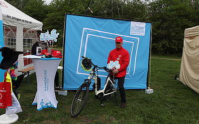 Ein MTV-Mitarbeiter auf einem Fahrrad am Stand "Nahmobilität, mobiles Hessen".