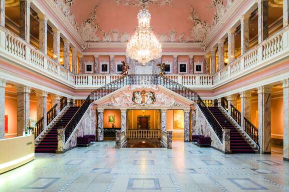 Der Marmorsaal mit Kronleuchter, doppeltem Treppenaufgang und Empore mit Säulengängen.