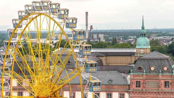 Ein großes gelbes Riesenrad vor dem Hintergrund historischer Gebäude in Darmstadt