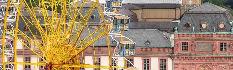 Ein großes gelbes Riesenrad vor dem Hintergrund historischer Gebäude in Darmstadt