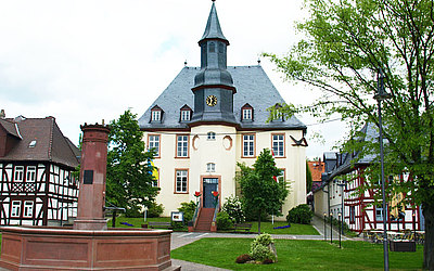 Vergrößerte Ansicht: Außenansicht Hugenottenkirche in Usingen mit Brunnen