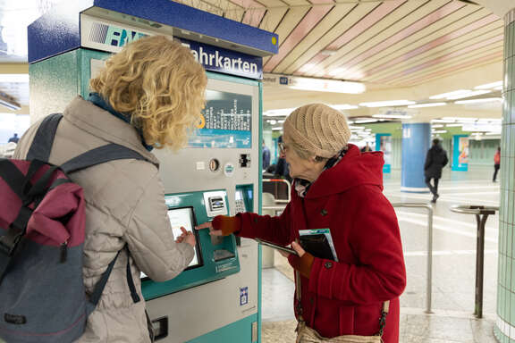 Zwei Seniorinnen bedienen einen Fahrkartenautomaten