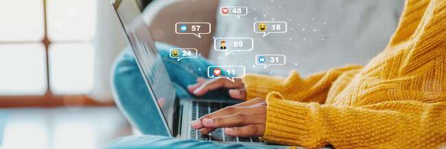 Frau mit Laptop auf dem Sofa darüber Sprechblasen mit Kommunikation-Icons