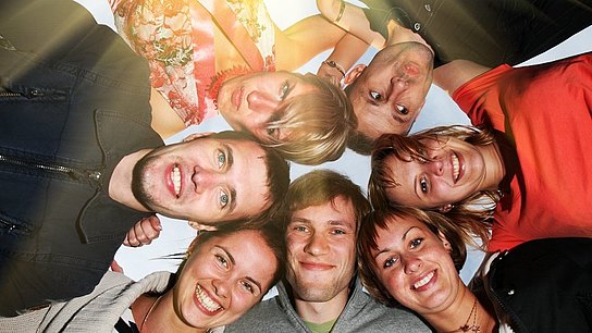 Eine Gruppe von Menschen schaut nach unten in die Kamera