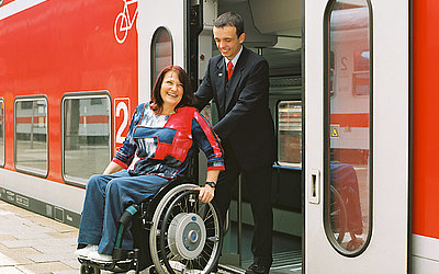 Vergrößerte Ansicht: Rollstuhlfahrerin beim Ausstieg aus einem Doppelstockzug mit Hilfe der ausfahrbaren Rampe