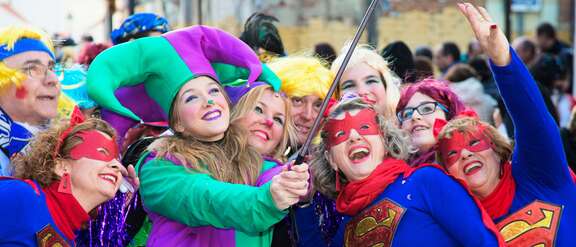 Kostümierte Karnevalistinnen posieren vor einem Selfie-Stick