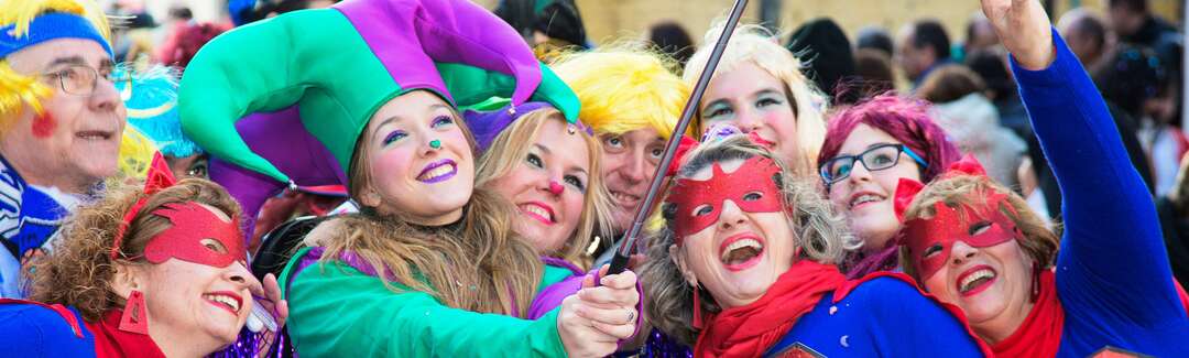 Kostümierte Karnevalistinnen posieren vor einem Selfie-Stick