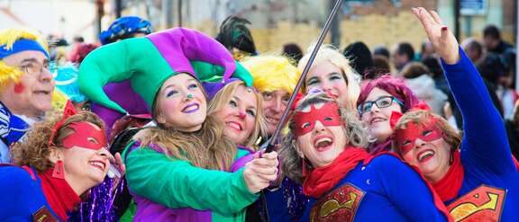 Kostümierte Karnevalistinnen posieren vor einem Selfie-Stick