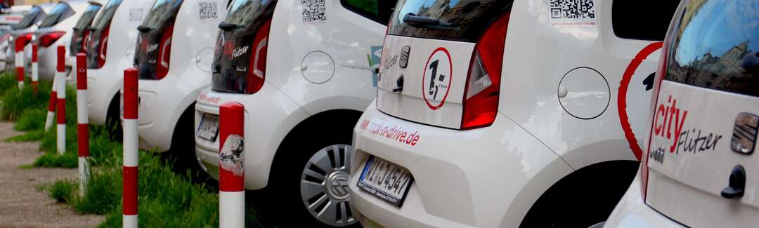 Mehrere Carsharing-Autos von hinten.