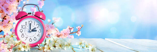 Auf dem Ziffernblatt verdeutlichen Zeiger, dass die Uhr um eine Stunde vorgestellt wird.