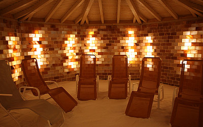 Vergrößerte Ansicht: Liegestühle in Salzgrotte vor Wand aus lichtdurchfluteten Glassteinen 