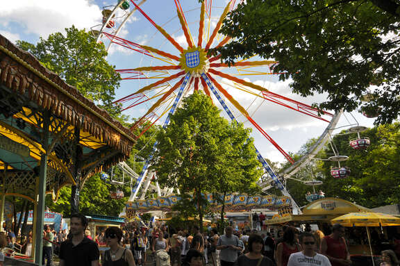Personen beim Frankfurter Wäldchestag, im Hintergrund ist ein Riesenrad zu sehen.