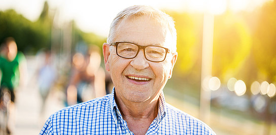 Zufriedener Senior lächelt in die Kamera