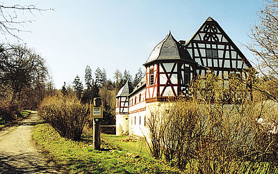 Vergrößerte Ansicht: Außenansicht eines Fachwerkhauses inmitten grüner Natur