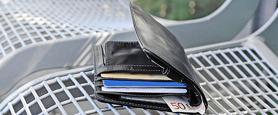 Geldbörse auf einer Bank am Bahnsteig