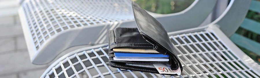 Geldbörse auf einer Bank am Bahnsteig