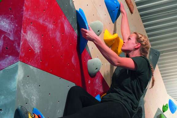 Eine Frau klettert in der Kletterhalle.