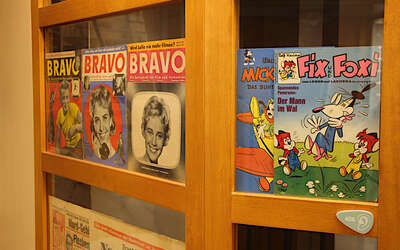 nachgebaute Kioskfassade aus Holz mit ausgehängten Zeitschriften und Comics