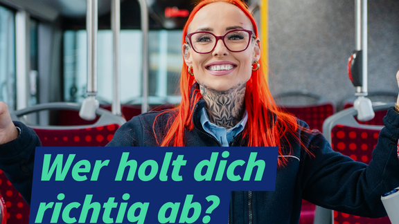Im Vordergrund eine junge, sympathische Busfaherin mit orangenen, langen Haaren, orangener Brille, Kreolen und einem Hals-Tattoo. Sie steht im Mittelgang eines Busses und lächelt in die Kamera. Unter dem Bild steht: Wer holt dich richtig ab? Erzähl uns von deinem/deiner Lieblingsbusfahrer/in! Rechts unten im Bild mit einem weißen Pfeil, unter dem steht: Darum geht's 