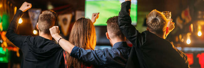 Public viewing Jubelnde Fans in einem Lokal vor einem Monitor