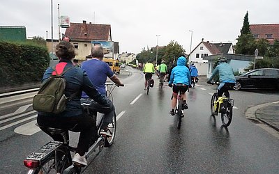 Gruppe von Menschen die auf einer Straße Fahrrad fahren