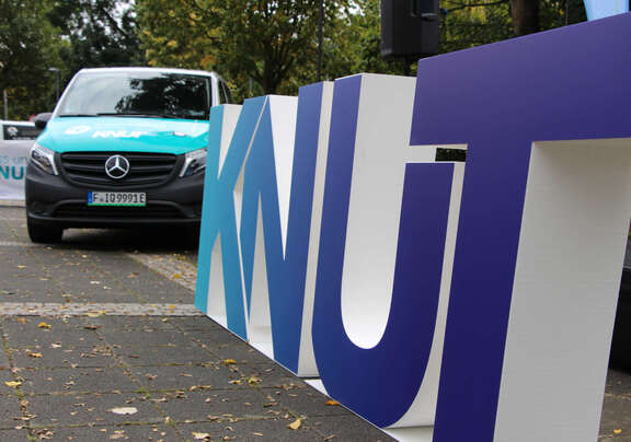 Vorderansicht des Elektroshuttles, aufgestellte Kunststoffbuchstaben "KNUT"