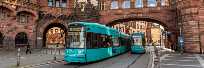Eine mintgrüne Straßenbahn in der Frankfurter Altstadt.