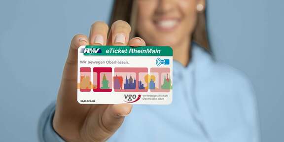 Junge Frau zeigt ihr VGO E-Ticket in die Kamera
