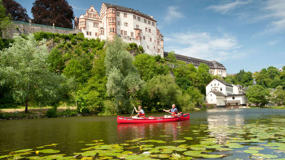 enlarged view: red canoe on the river Lahn, blue sky, lush green 