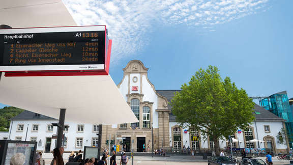Digital display panel with bus information, in the background station building