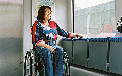 Vergrößerte Ansicht: Rollstuhlfahrerin blickt aus dem Fenster eines Doppelstockzugs