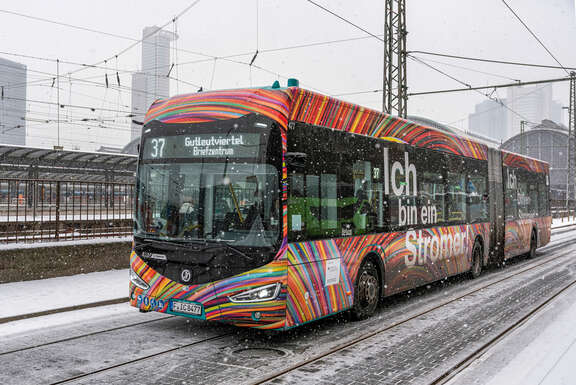 Bus der Linie 37 im Schneetreiben mit dem Frankfurter Hauptbahnhof im Hintergrund